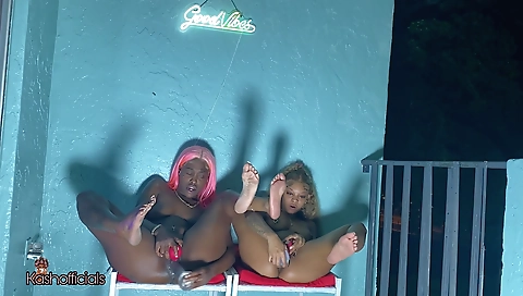 Ebony and black lesbians are on the balcony playing with their toys